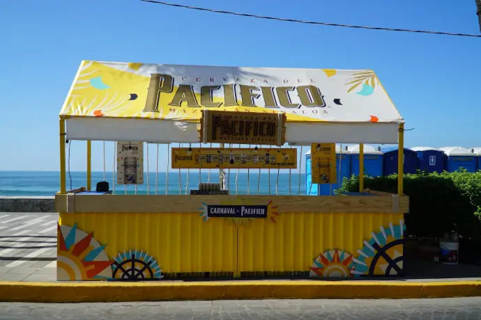 Barra simple amarilla de Cerveza Pacifico frente al mar para el Carnaval de Mazatlán 2026.
