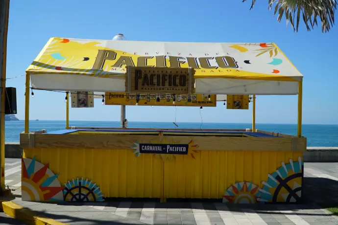Barra doble amarilla de Cerveza Pacífico frente al mar para el Carnaval de Mazatlán 2026.