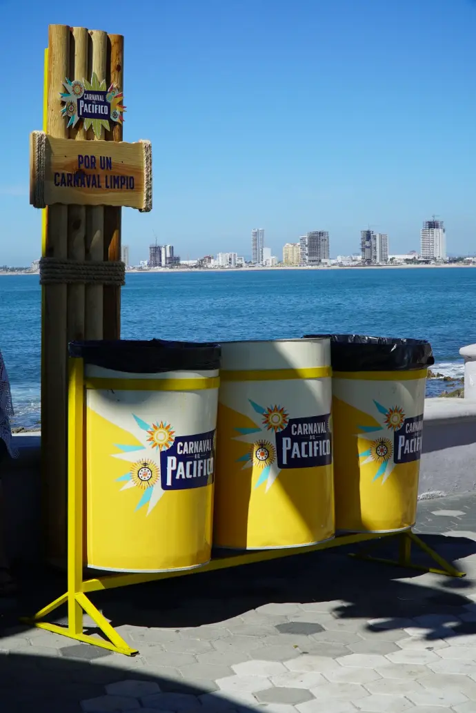 Botes de basura de Cerveza Pacífico para el Carnaval de Mazatlán 2026 con el mar de fondo.