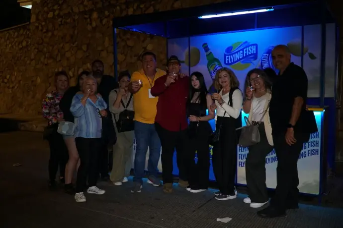 Barra de samplers de Flying Fish con personas disfrutando de muestras gratis durante la noche. 