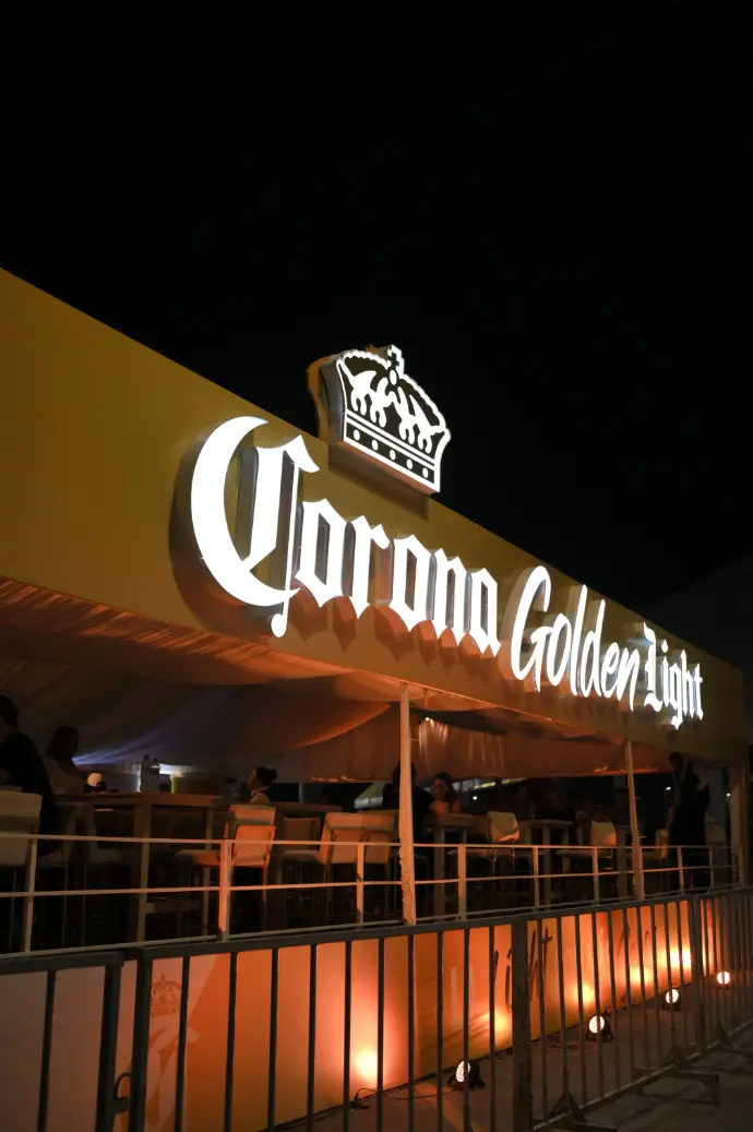 Vista nocturna de la Terraza VIP de Corona Golden Light con letrero iluminado y estructura implementada por Entorno Lab en la Feria de Torreón 2024.