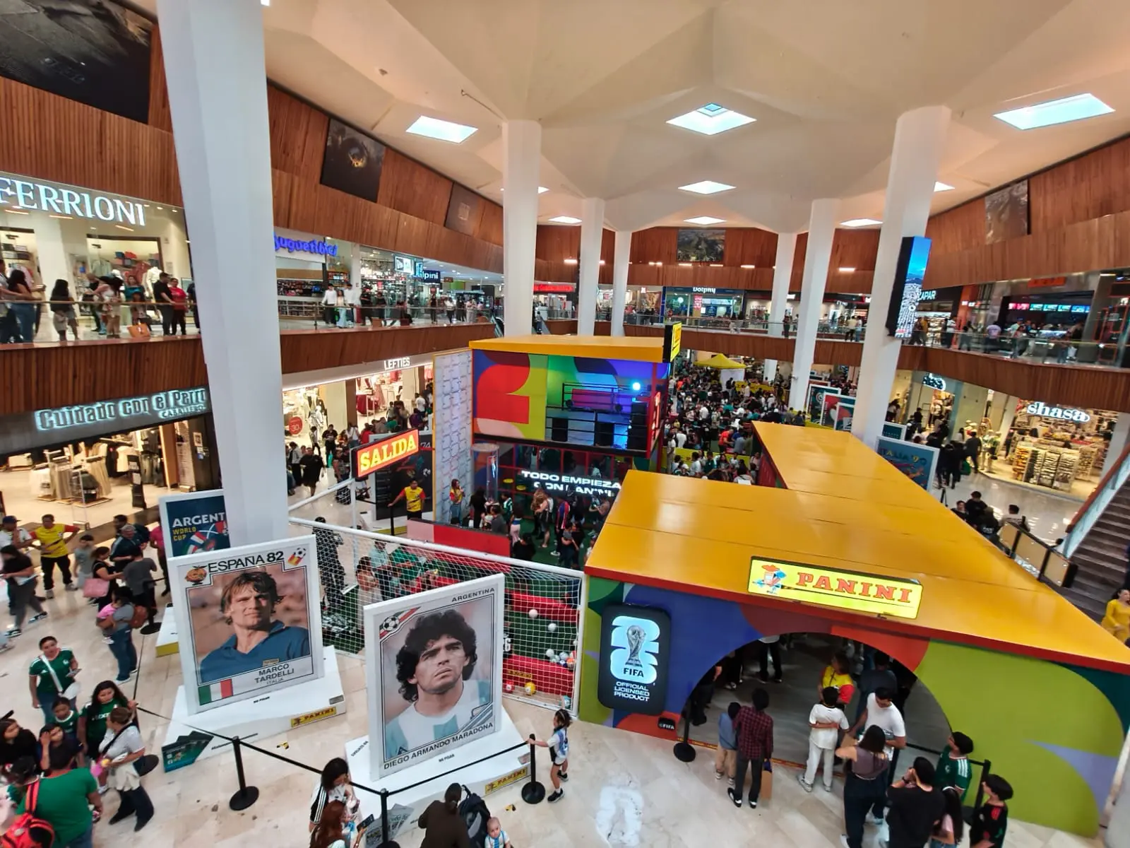 Galería de leyendas del Mundial Visitantes junto a los retratos gigantes de leyendas del Mundial como Maradona y Tardelli en la activación Panini