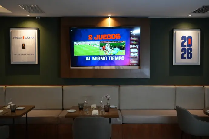 TV Michelob Ultra transmisión Mundial 2026 Pantalla con transmisión del Mundial 2026 flanqueada por cuadros de Michelob Ultra y FIFA World Cup 26 en restaurante de hotel